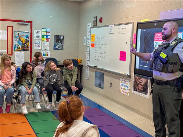 police officer talking to class of students